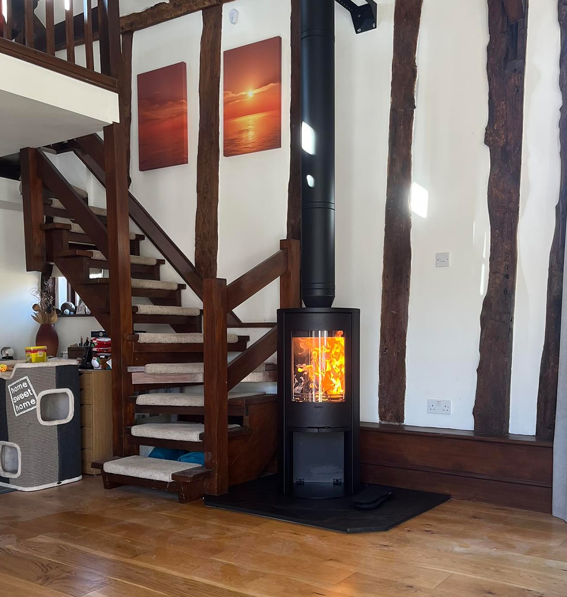 Cylinder wood stove by an open staircase